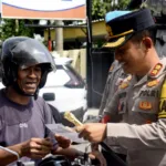 Kapolres Bondowoso membagikan brosur bagi pengguna jalan dalam Operasi Zebra Semeru 2025