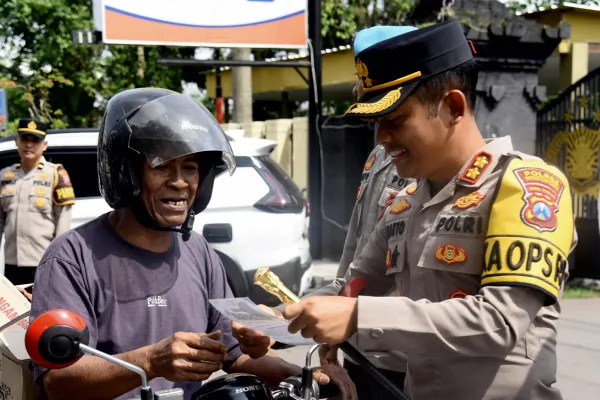 Kapolres Bondowoso membagikan brosur bagi pengguna jalan dalam Operasi Zebra Semeru 2025